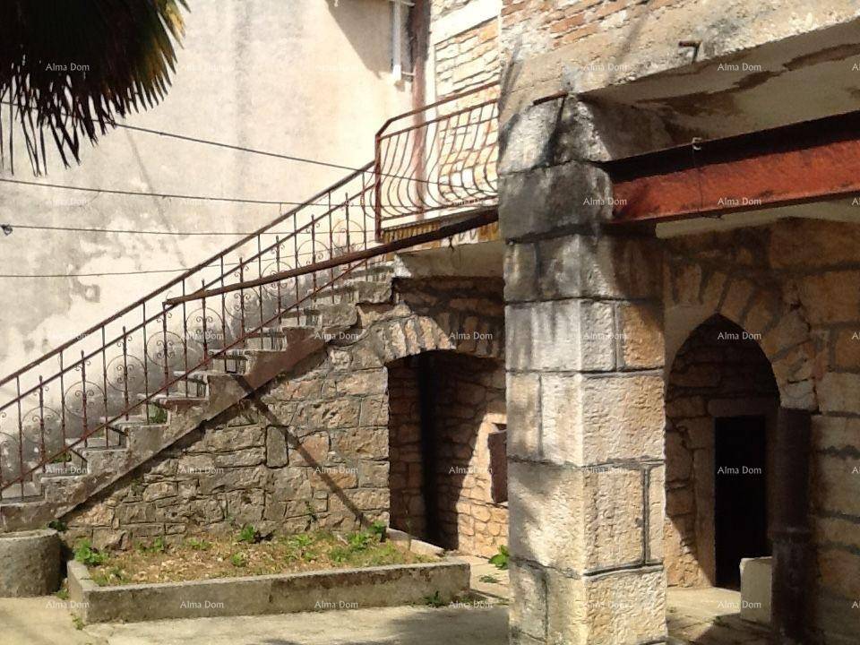 Alte Steintreppe und gemauerte Bögen an der Fassade eines traditionellen Gebäudes.