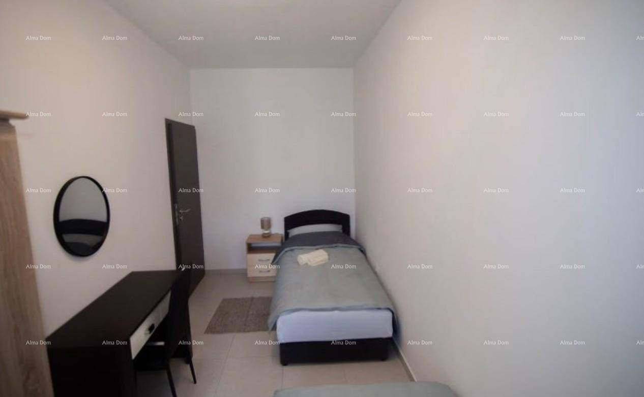 Kompaktes Schlafzimmer mit Einzelbett, Schreibtisch und ovalem Wandspiegel.