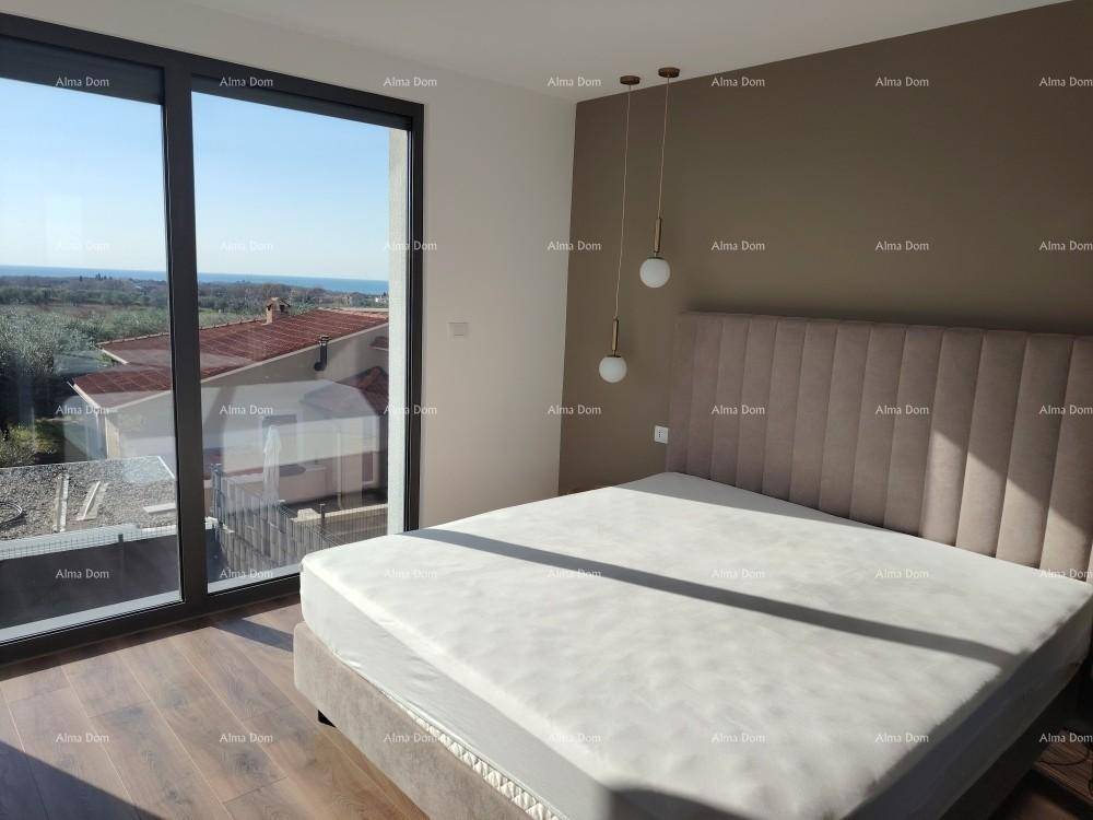 Helles Schlafzimmer mit großem Bett, Akzentwand und bodentiefen Fenstern mit Meerblick.