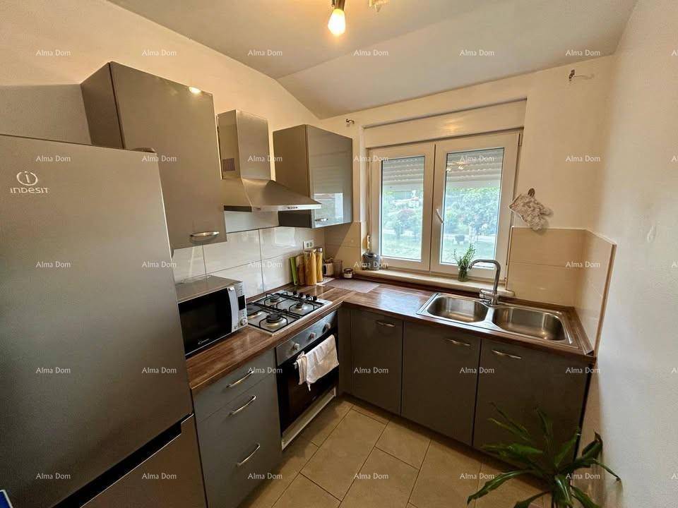 Moderne Küche mit grauen Schränken, Gasherd, Backofen und großem Kühlschrank.