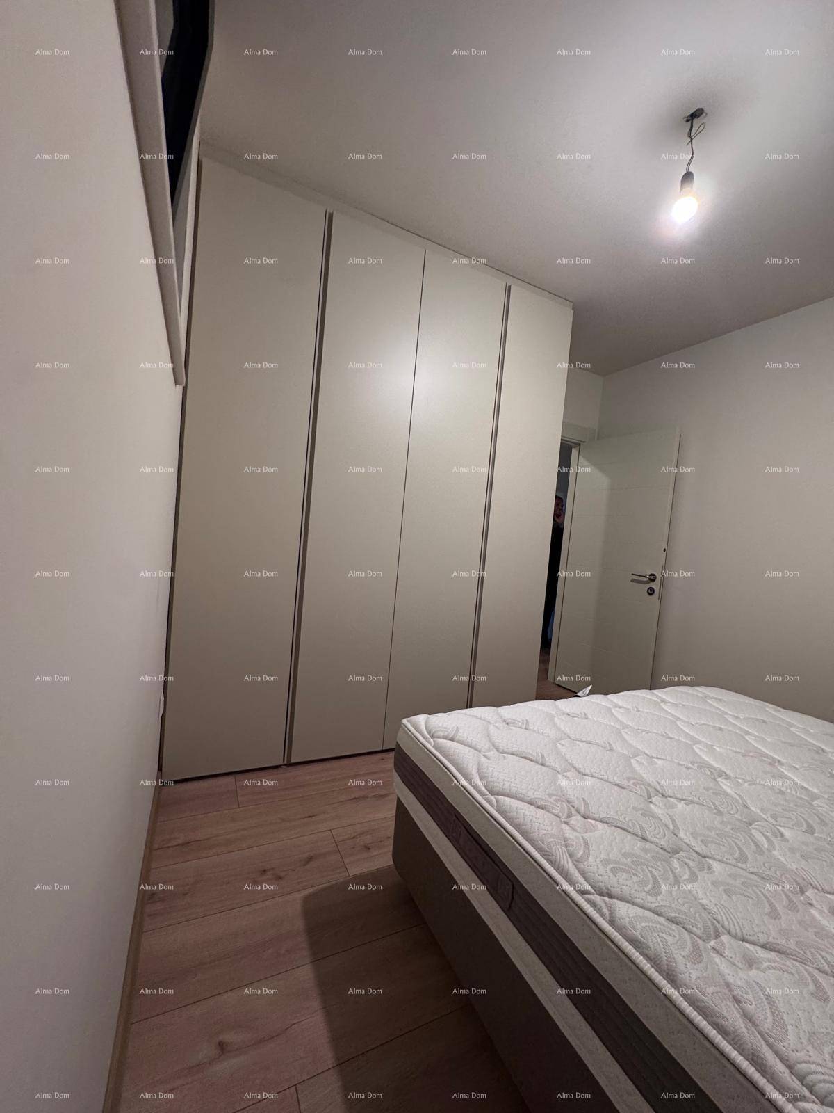 Schlafzimmer mit Holzboden, bequemer Matratze und praktischen Einbauschränken entlang der Wand.