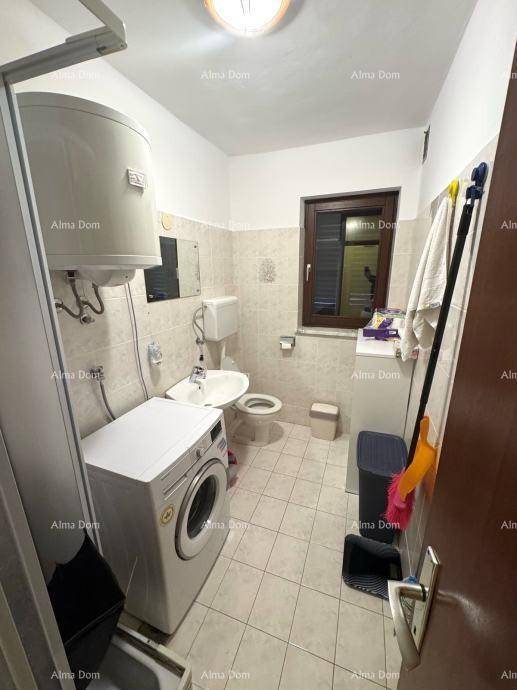 Modernes Badezimmer mit Fliesen, Dusche, Waschmaschine und einem Fenster für Tageslicht.