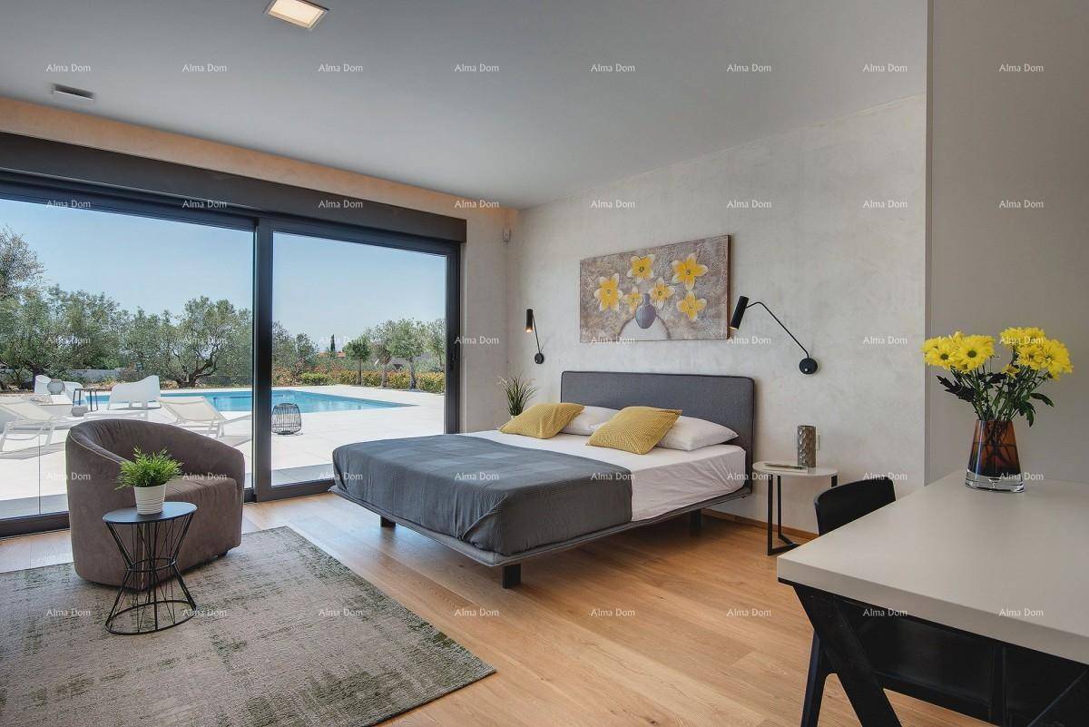 Freundliches Schlafzimmer mit Doppelbett, Holzboden und Blick auf den Pool und die grüne Umgebung.