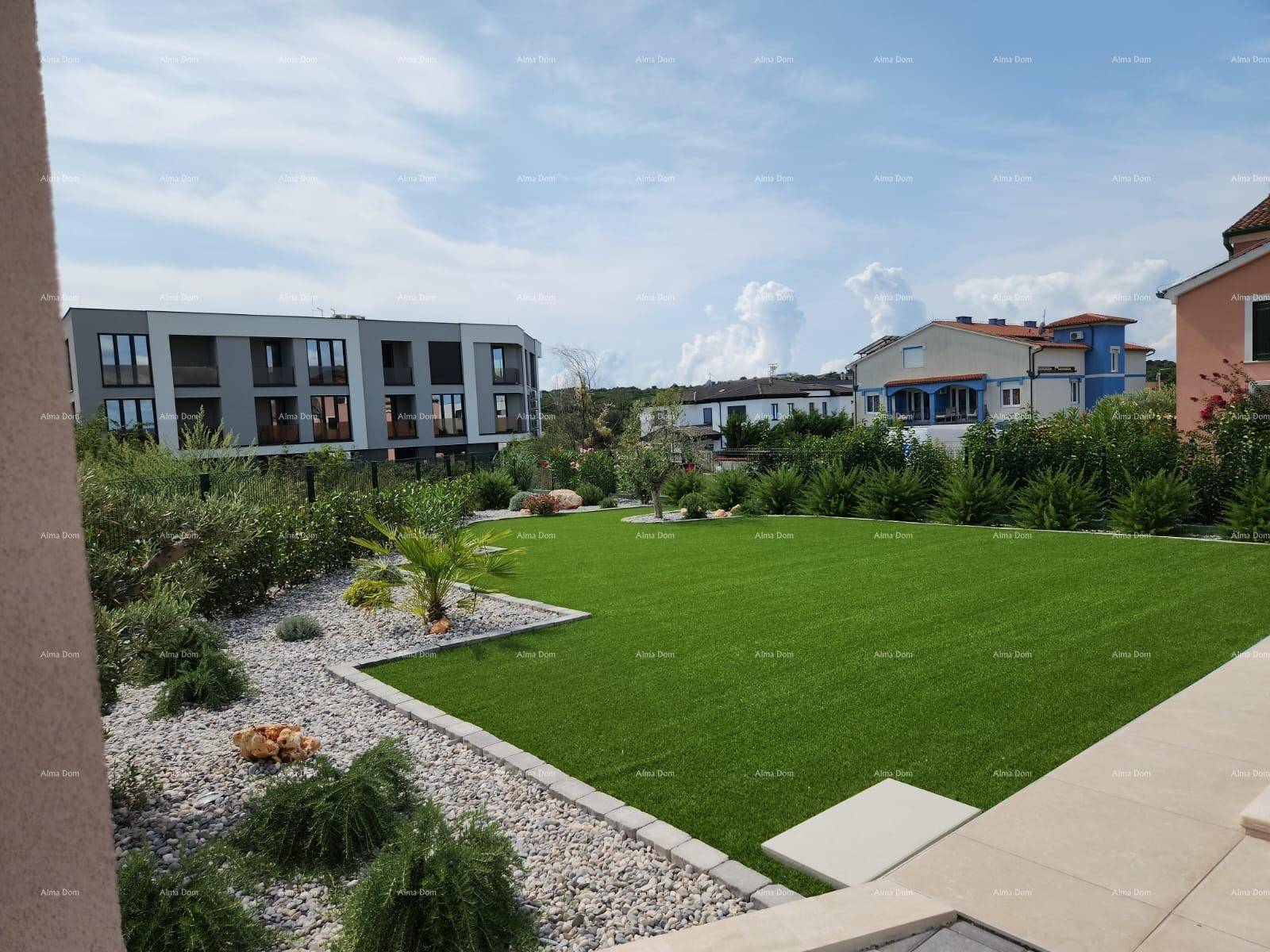 Weitläufiger, gepflegter Gartenbereich mit Zierpflanzen, Kiesbeeten und Blick auf benachbarte moderne Gebäude.