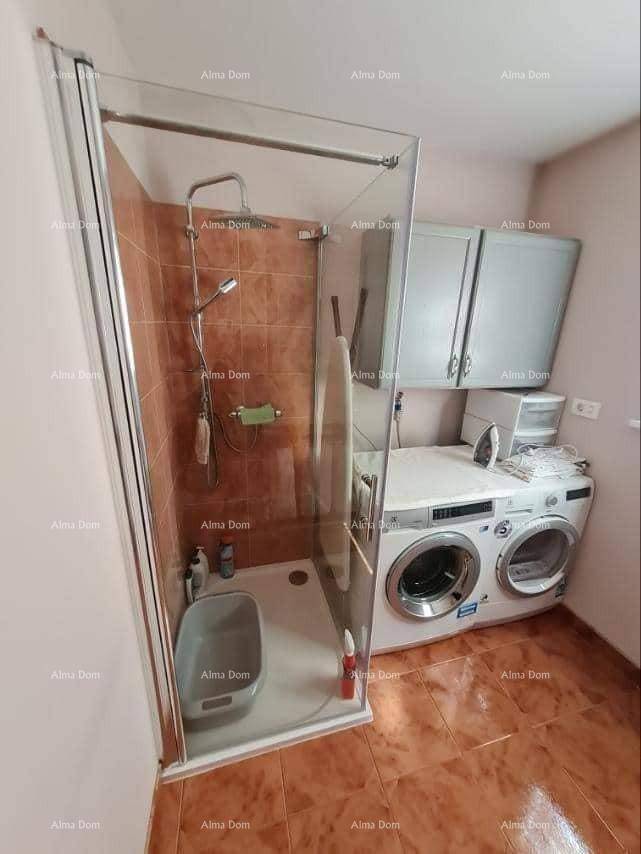 Badezimmer mit Duschkabine, Waschmaschine und Trockner sowie praktischen Hängeschränken.
