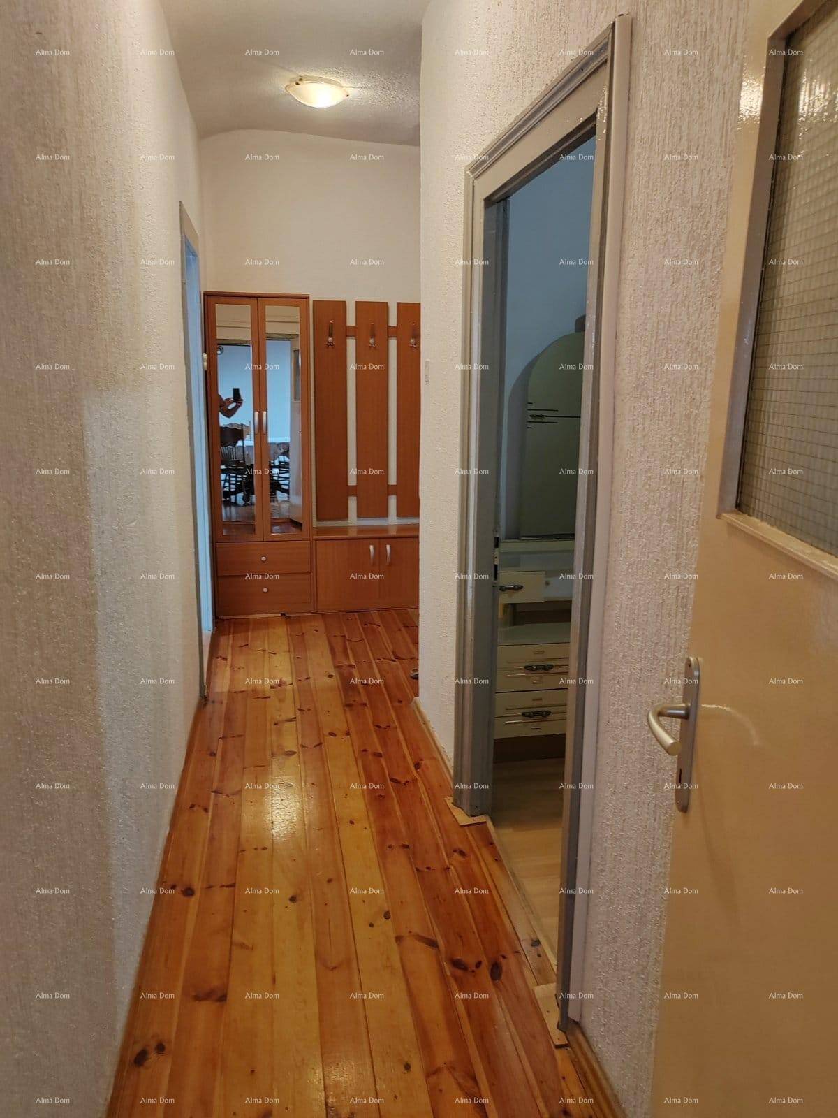 Langer Flur mit Holzboden und Garderobe, der zu weiteren Räumen führt.