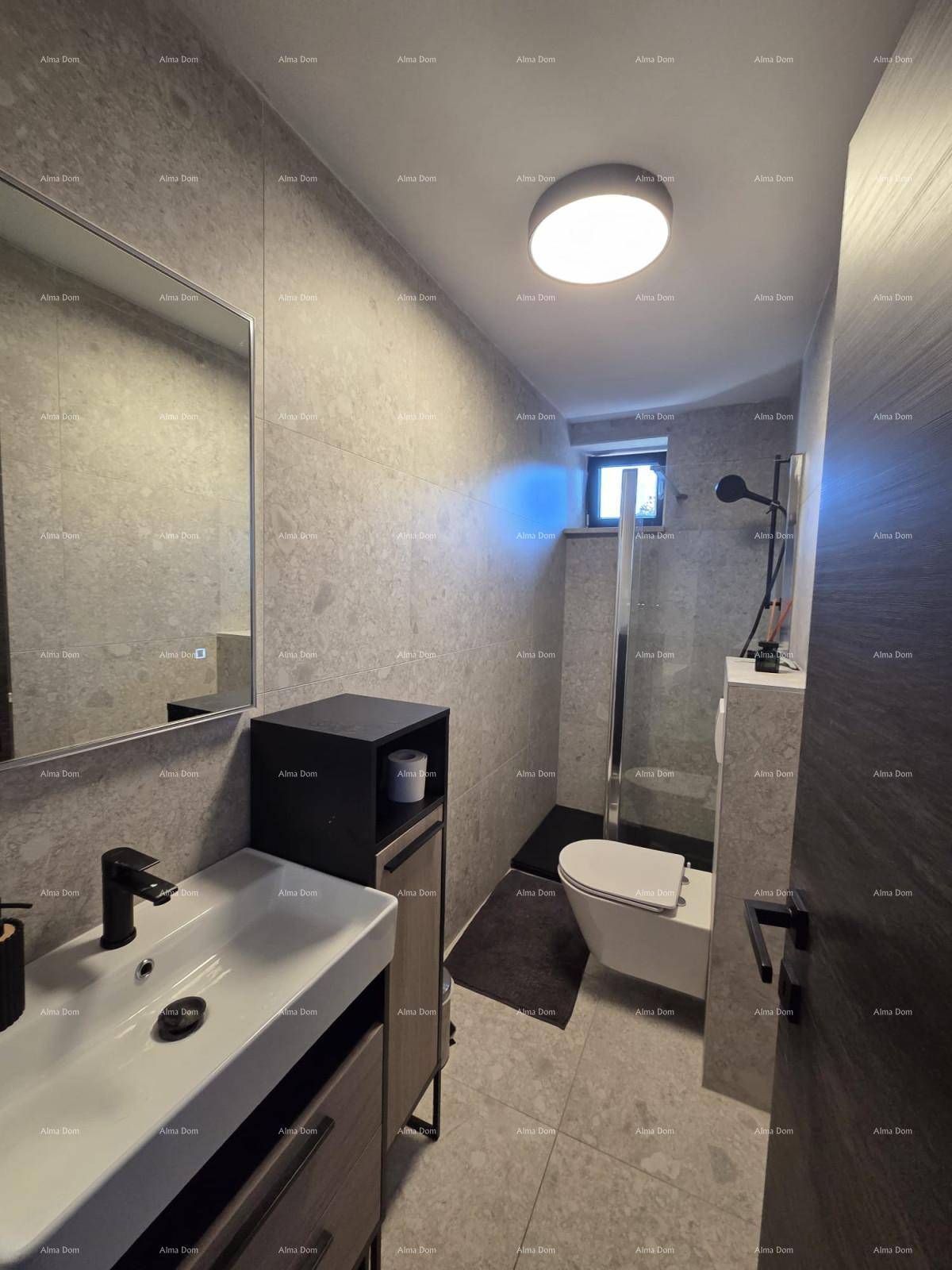 Modernes Badezimmer mit grauen Fliesen, ebenerdiger Dusche, wandhängendem WC und Fenster.