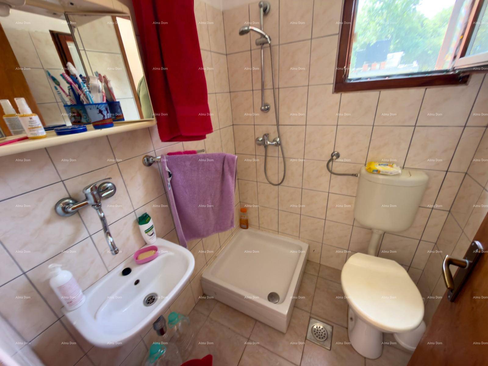 Kleines Badezimmer mit Duschwanne, WC und Waschbecken, praktisch und hell gefliest.