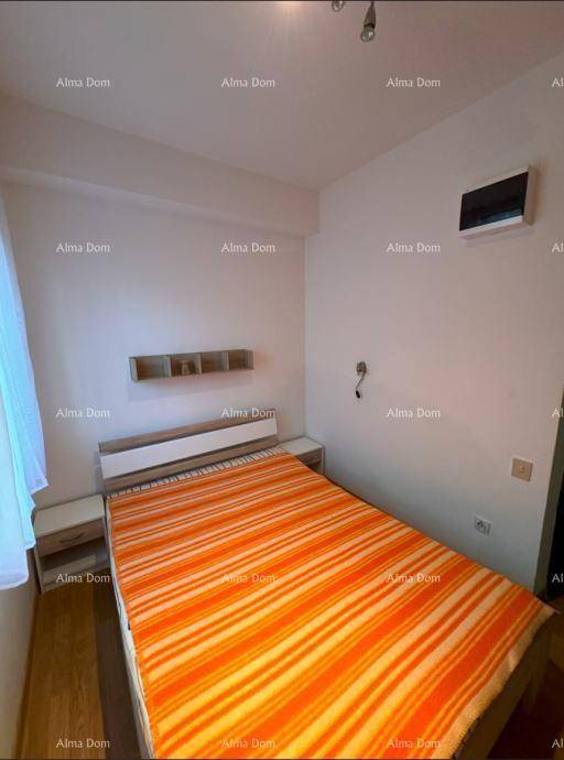 Helles Schlafzimmer mit Einzelbett, orange gestreifter Decke und schlichten Wandregalen.
