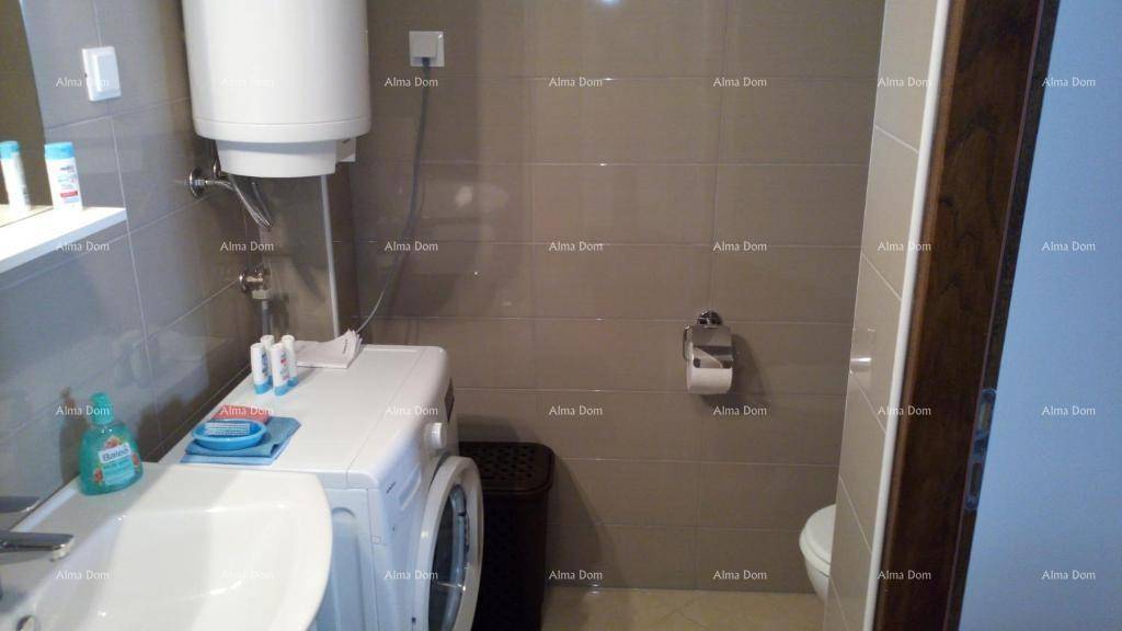 Badezimmer mit Waschmaschine, Waschbecken und Toilette, praktisch eingerichtet.