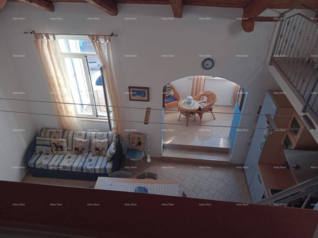 Blick von oben auf den offenen Wohnbereich mit Sofa, Esstisch und Zugang zu einem weiteren Raum.