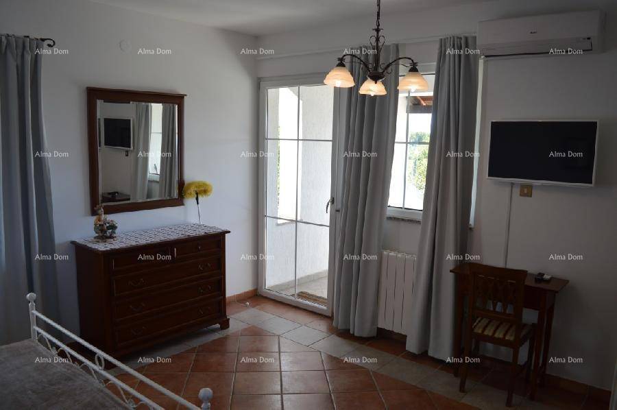Schlafzimmer mit Doppelbett, Kommode und Zugang zu einem Balkon, ausgestattet mit Klimaanlage.