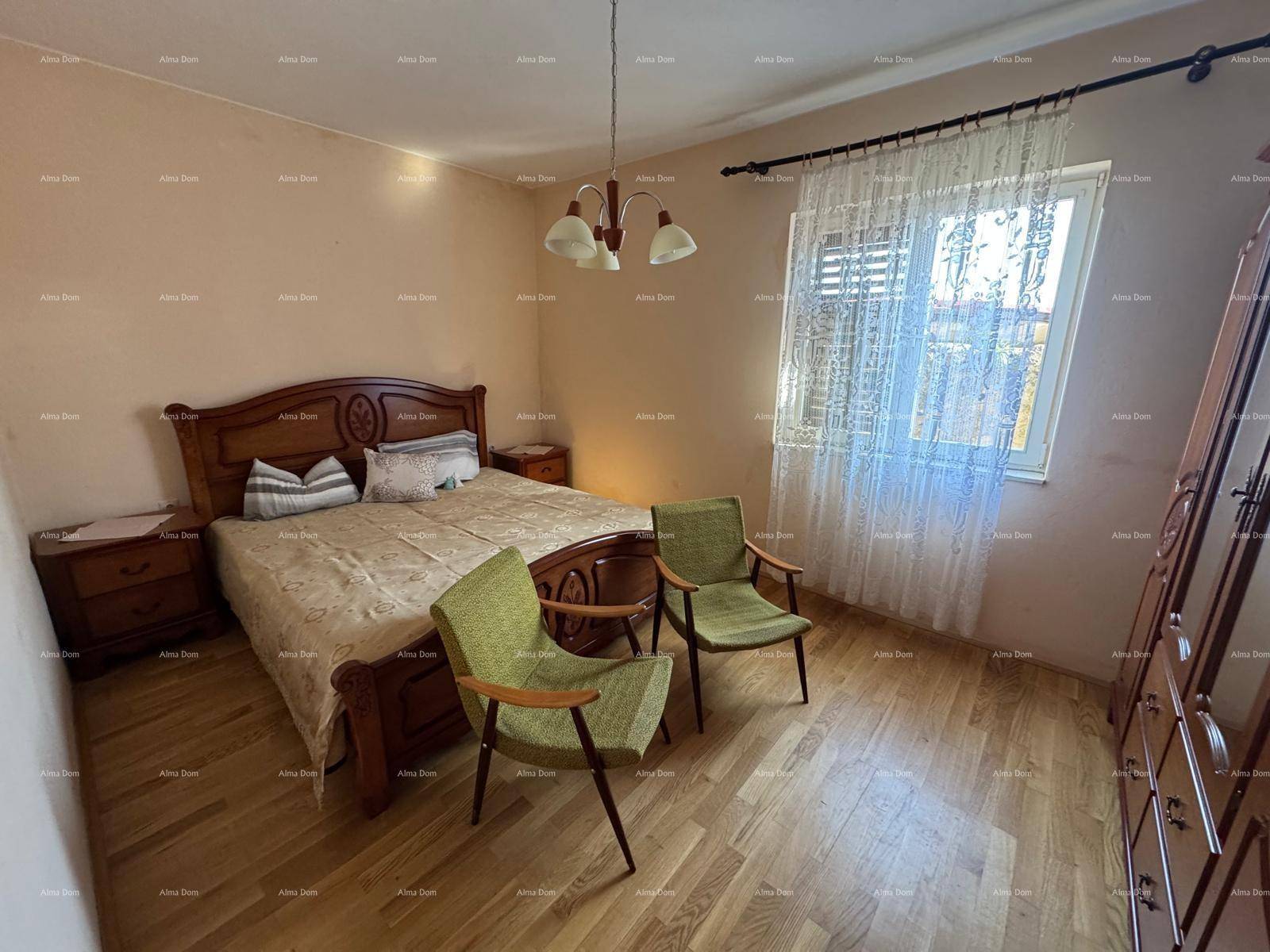Geräumiges Schlafzimmer mit Doppelbett, Holzmöbeln und Parkettboden, gut beleuchtet.