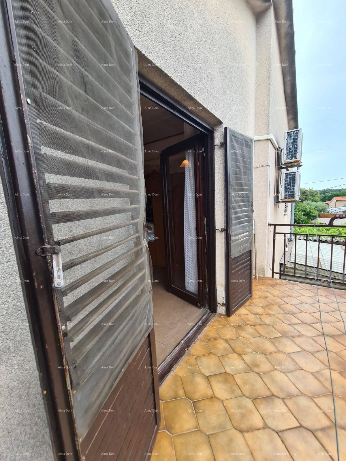 Balkon mit Fliesenboden, braunen Fensterläden und einem Geländer mit Blick auf die Umgebung.
