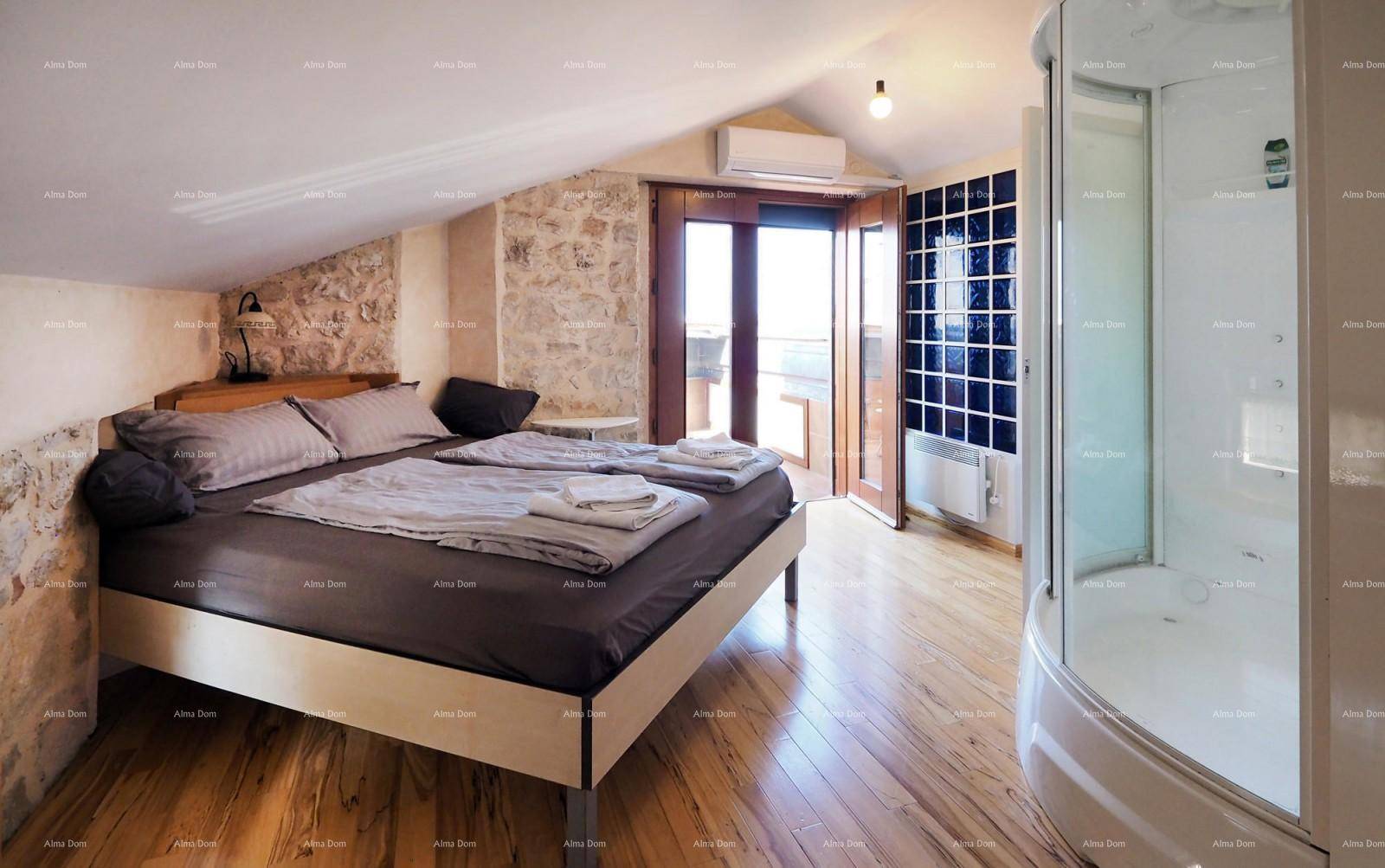 Schlafzimmer im Dachgeschoss mit Doppelbett, Duschkabine und Zugang zum Balkon.