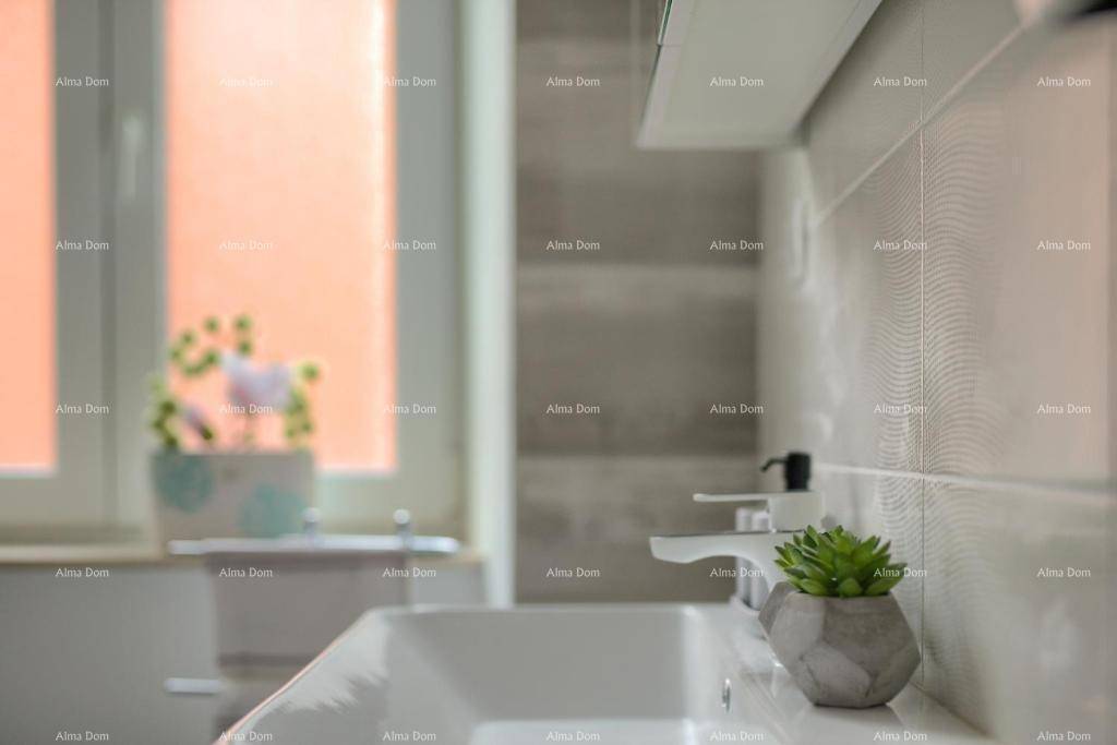 Detailansicht eines modernen Waschbeckens mit stilvollem Wasserhahn und grüner Dekoration.