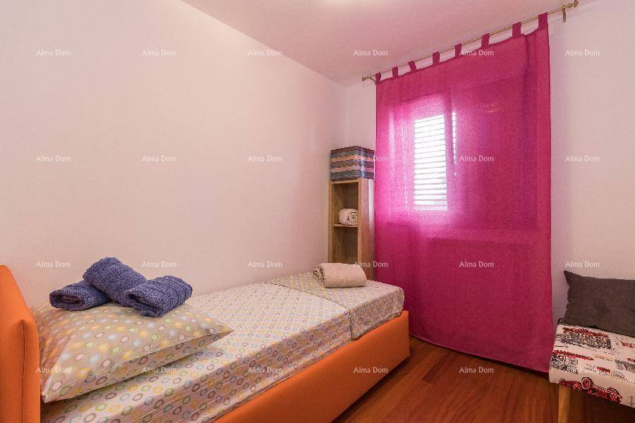 Helles Schlafzimmer mit Einzelbett, Holzfußboden und auffälligen pinken Vorhängen.