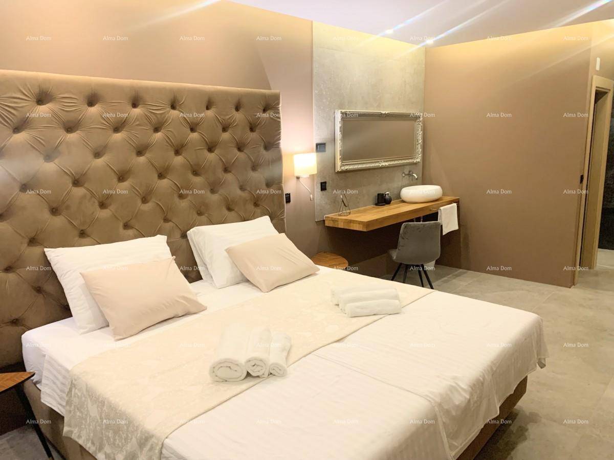 Gemütliches Schlafzimmer mit großem Bett, gepolstertem Kopfteil und offenem Waschtischbereich im Zimmer.