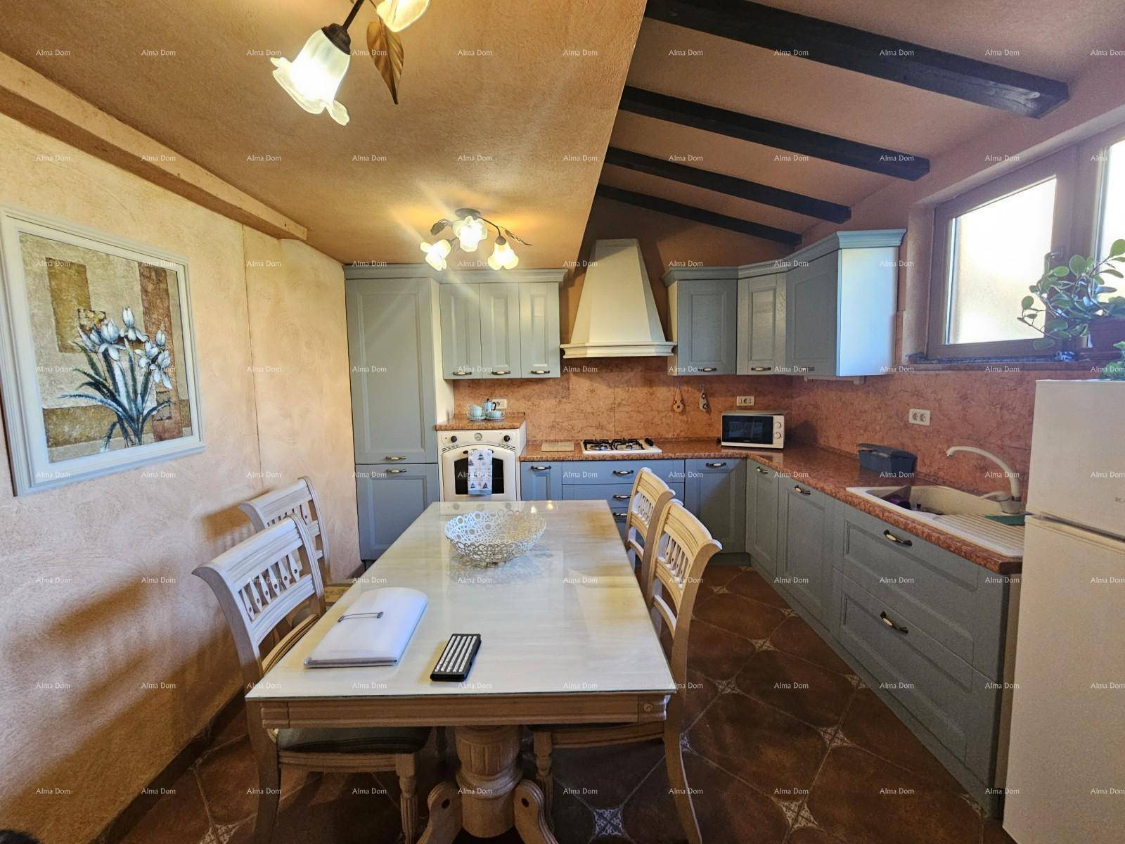 Rustikale Küche mit hellblauen Schränken, einem Esstisch und sichtbaren Holzbalken an der Decke.