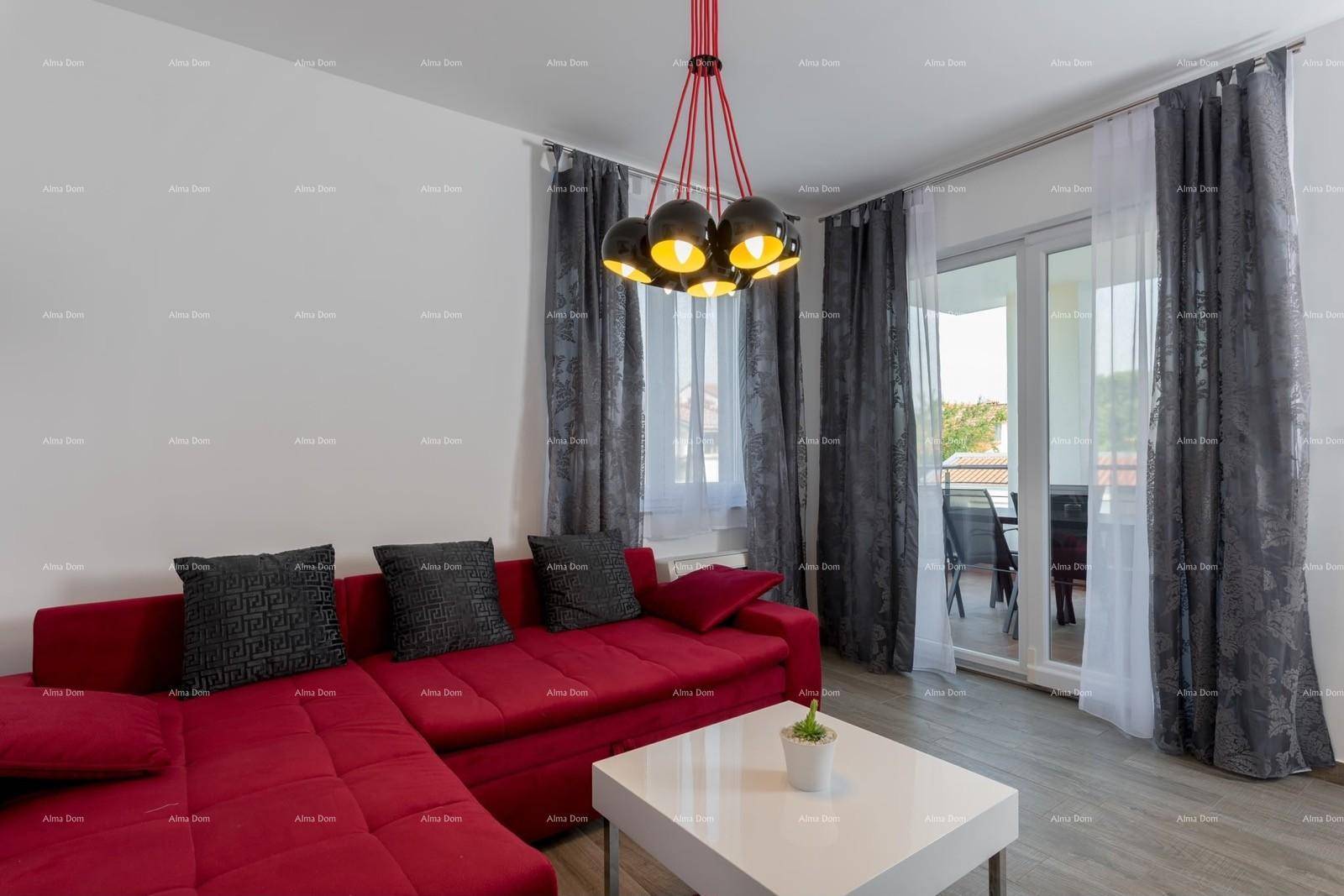 Helles Wohnzimmer mit rotem Ecksofa, modernem Couchtisch und Zugang zum Balkon.