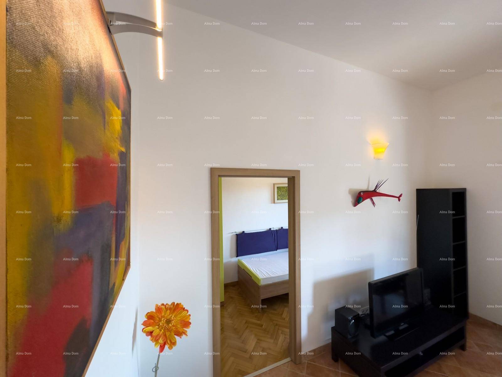 Blick vom Wohnbereich in ein Schlafzimmer mit Holzboden und moderner Einrichtung.