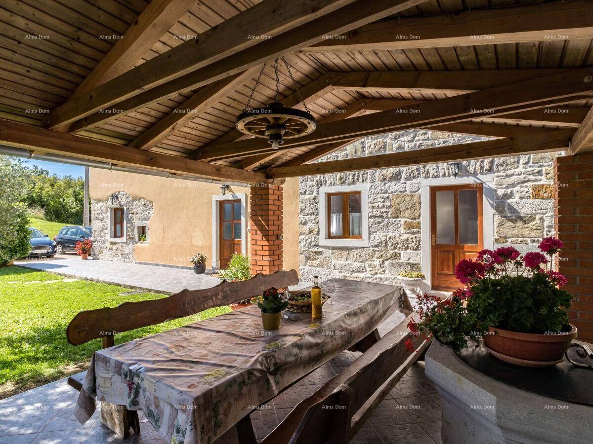 Überdachte Terrasse mit Holztisch und Bänken, ideal für Mahlzeiten im Freien.
