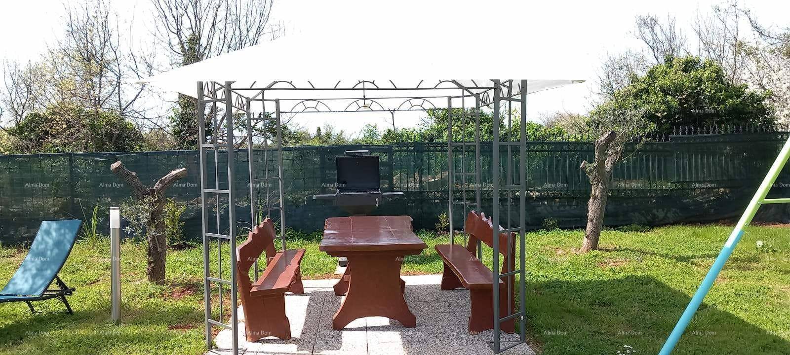 Gemütlicher Gartenbereich mit einem Pavillon, Holzbänken und einem Grillplatz im Grünen.