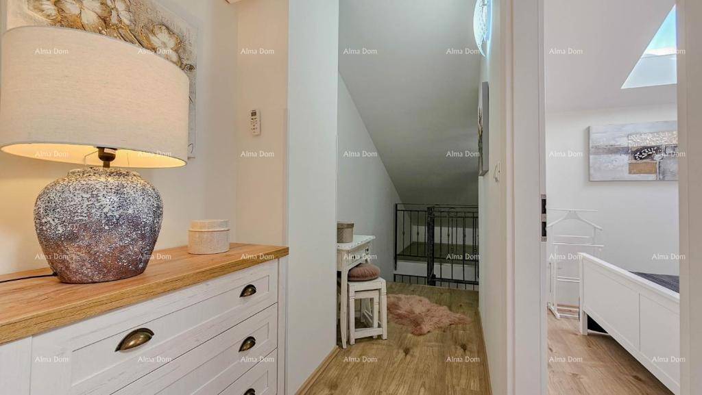 Heller Flur mit Kommode, Lampe und Blick auf die Treppe und ein Schlafzimmer.