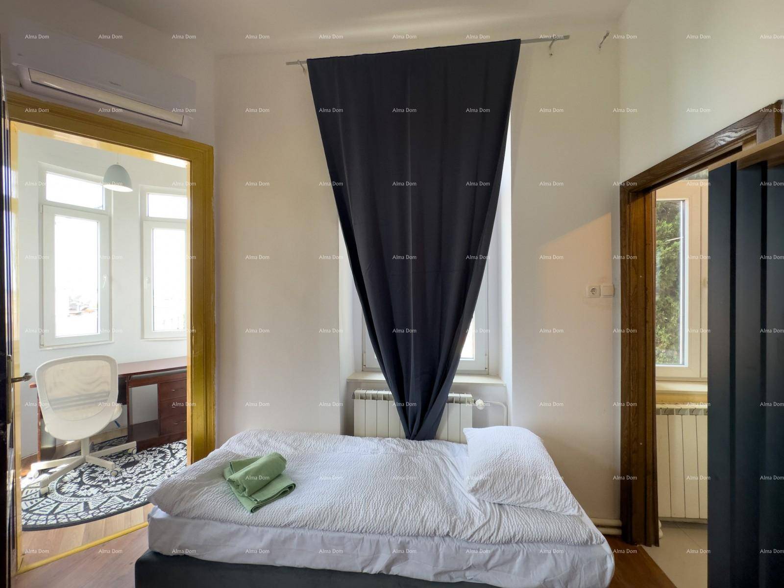 Gemütliches Schlafzimmer mit Einzelbett, Fenster und Zugang zu einem hellen Arbeitsbereich.