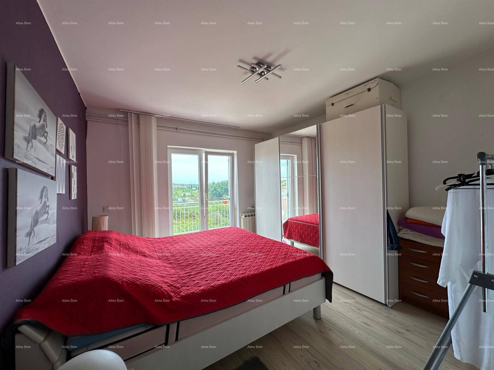 Schlafzimmer mit rotem Bett, weißem Kleiderschrank und hellem Balkonzugang.