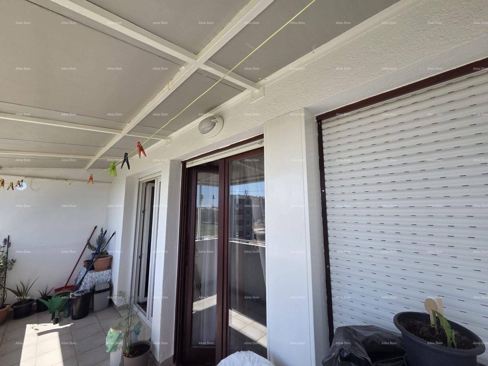 Überdachter Balkon mit Fliesenboden und Wäscheleine, bietet Platz für Pflanzen und Entspannung.