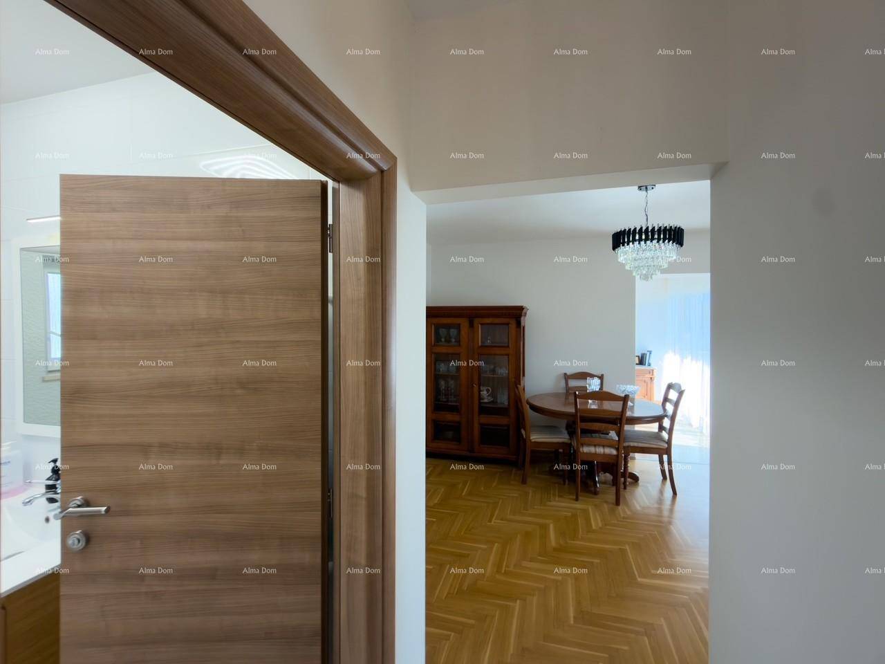 Flur mit Holztür zum Badezimmer und offenem Zugang zum Essbereich mit Holzboden.