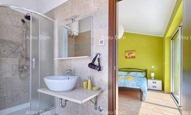 Modernes Badezimmer mit Duschkabine, Waschbecken und Blick auf das angrenzende Schlafzimmer.