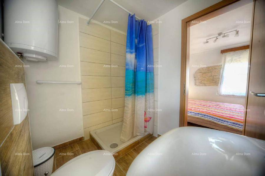 Badezimmer mit Duschbereich, WC und Waschbecken, direkt vom Schlafzimmer aus zugänglich.