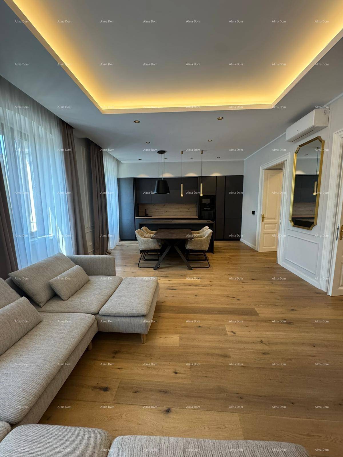 Heller Wohn-Essbereich mit beiger Couch, Holzboden und moderner schwarzer Küche.