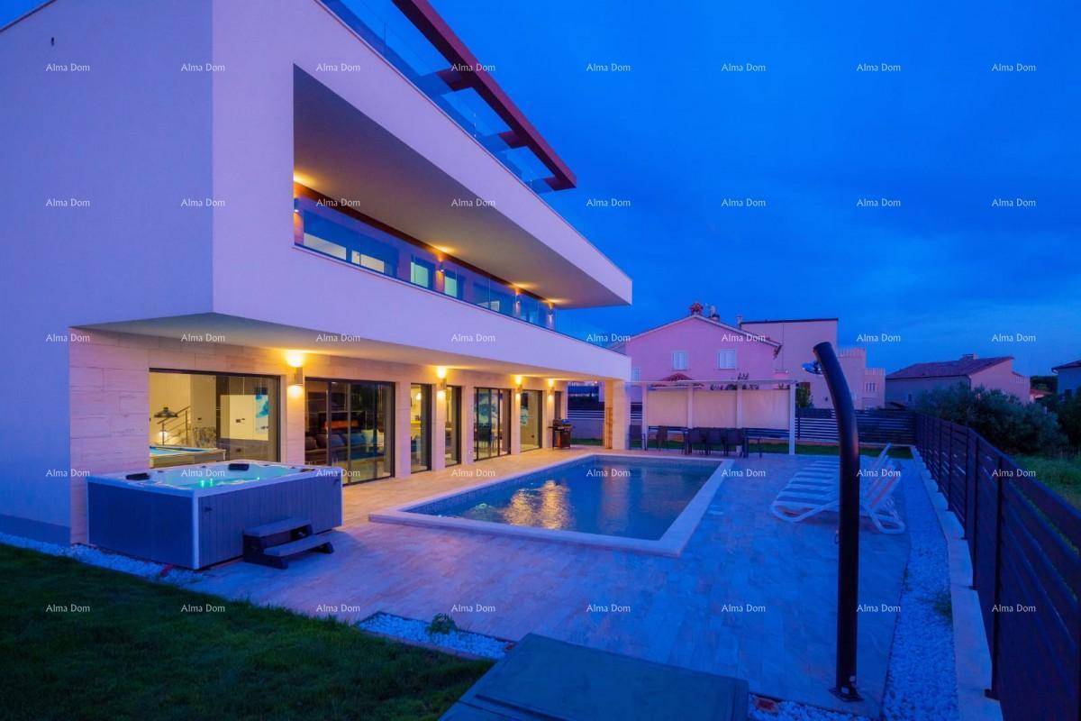 Luxuriöse Villa bei Sonnenuntergang mit beleuchtetem Pool und Whirlpool, umgeben von moderner Architektur.