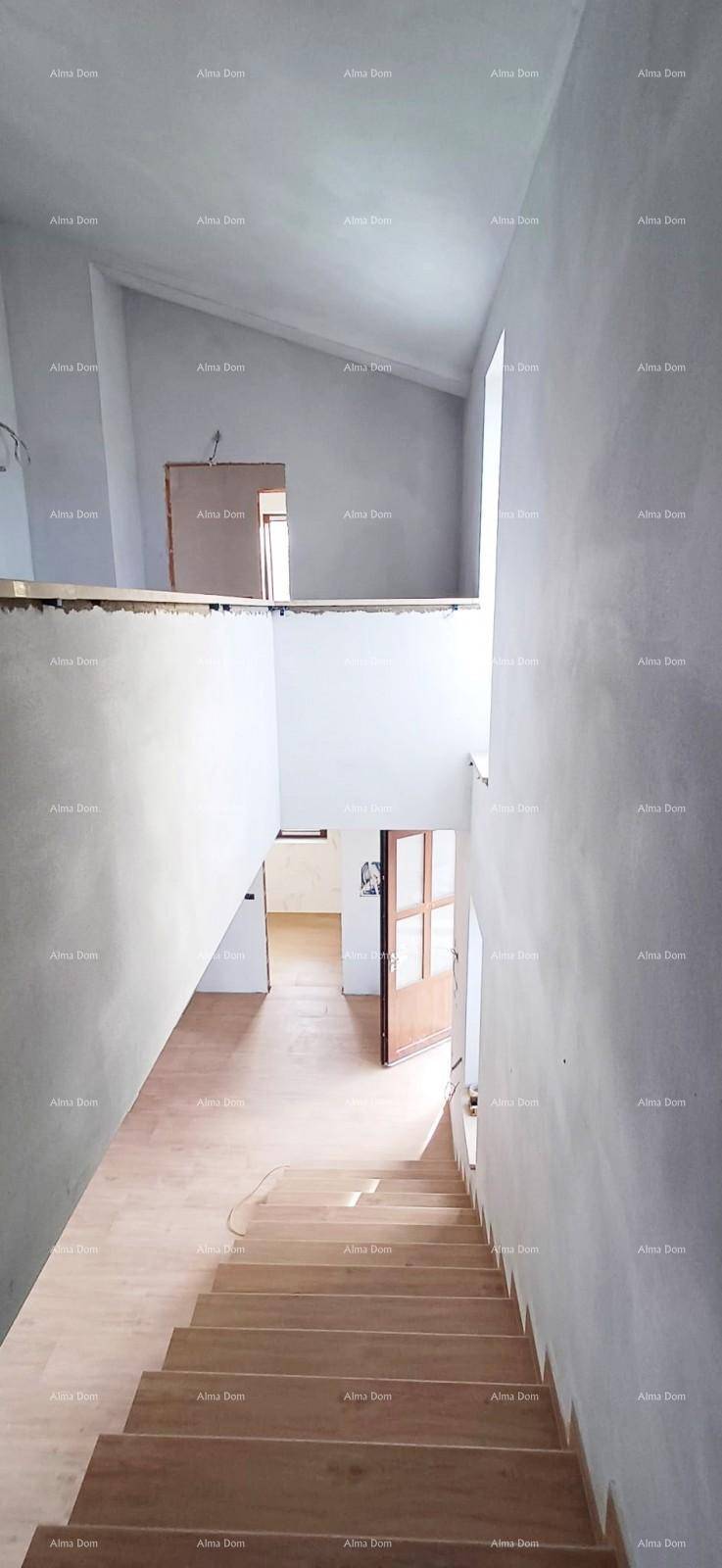Offener Wohnbereich im Rohbau mit mehreren Türöffnungen und Holzboden.