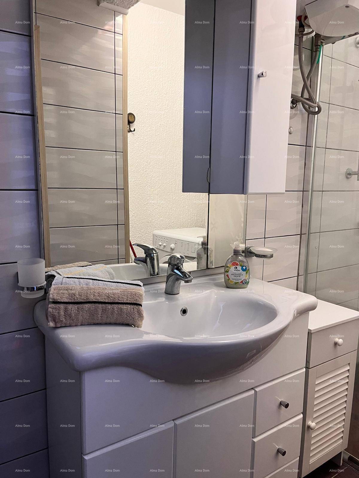 Modernes Badezimmer mit Waschbecken, Spiegelschrank und hellen Fliesen an den Wänden.