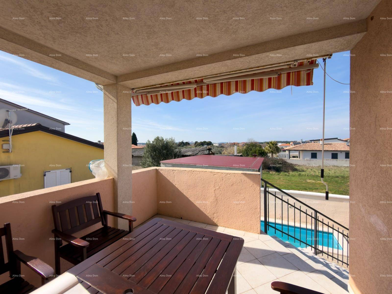 Überdachter Balkon mit Holztisch und Stühlen, ideal für Mahlzeiten im Freien.