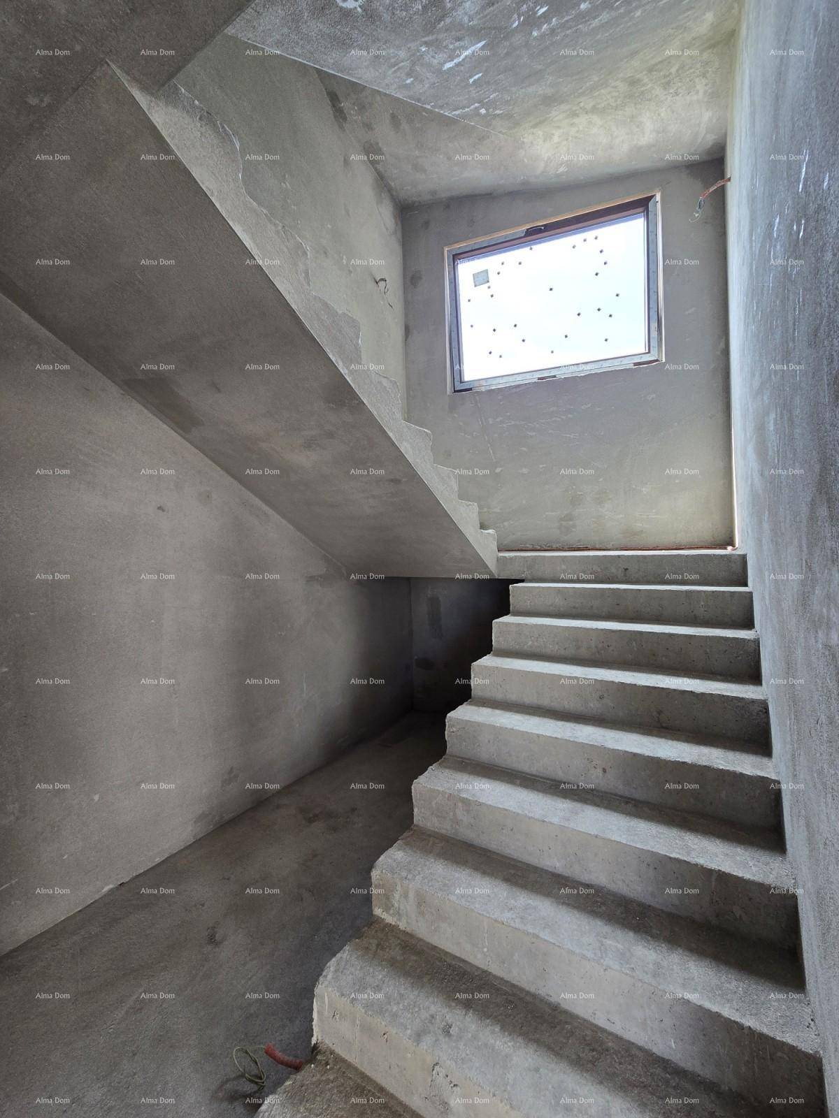 Unfertiges Treppenhaus aus Beton mit einem Fenster, das natürliches Tageslicht hereinlässt.