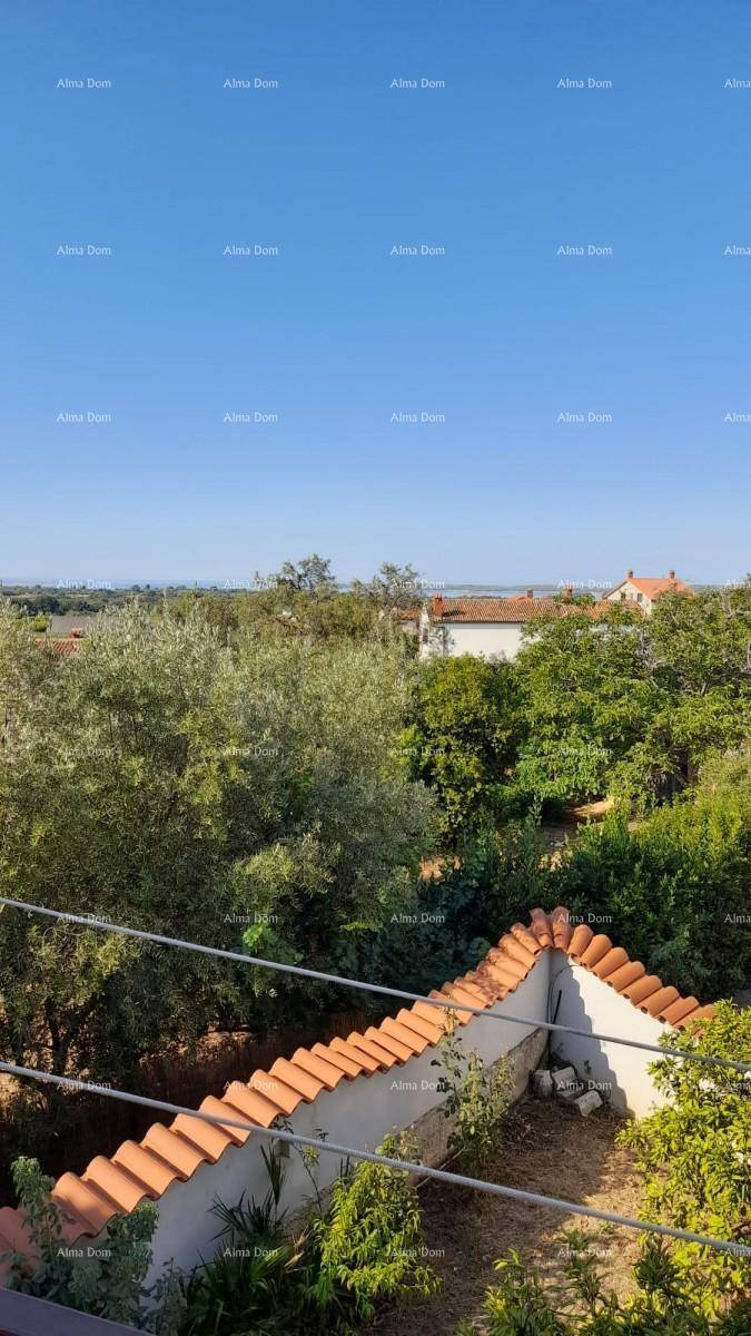 Panoramablick von einem Balkon über die grüne Landschaft mit mediterranen Dächern und blauem Himmel.