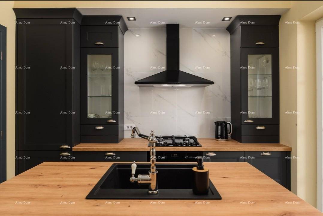 Elegante schwarze Küche mit Holz-Arbeitsplatten, Gasherd und moderner Dunstabzugshaube.