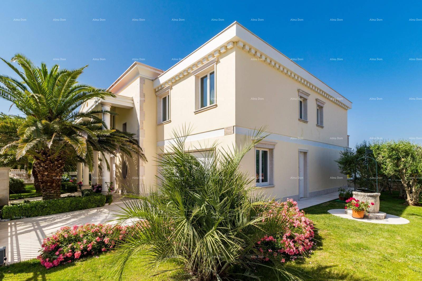 Seitlicher Blick auf die Villa mit gepflegtem Garten, Palmen und einem Brunnen im mediterranen Stil.