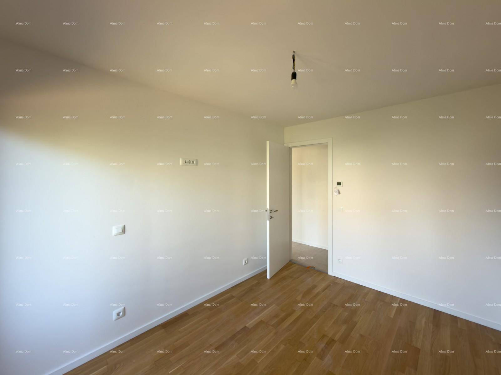 Leeres Zimmer mit Holzboden und weiß gestrichenen Wänden, bereit für die Einrichtung.