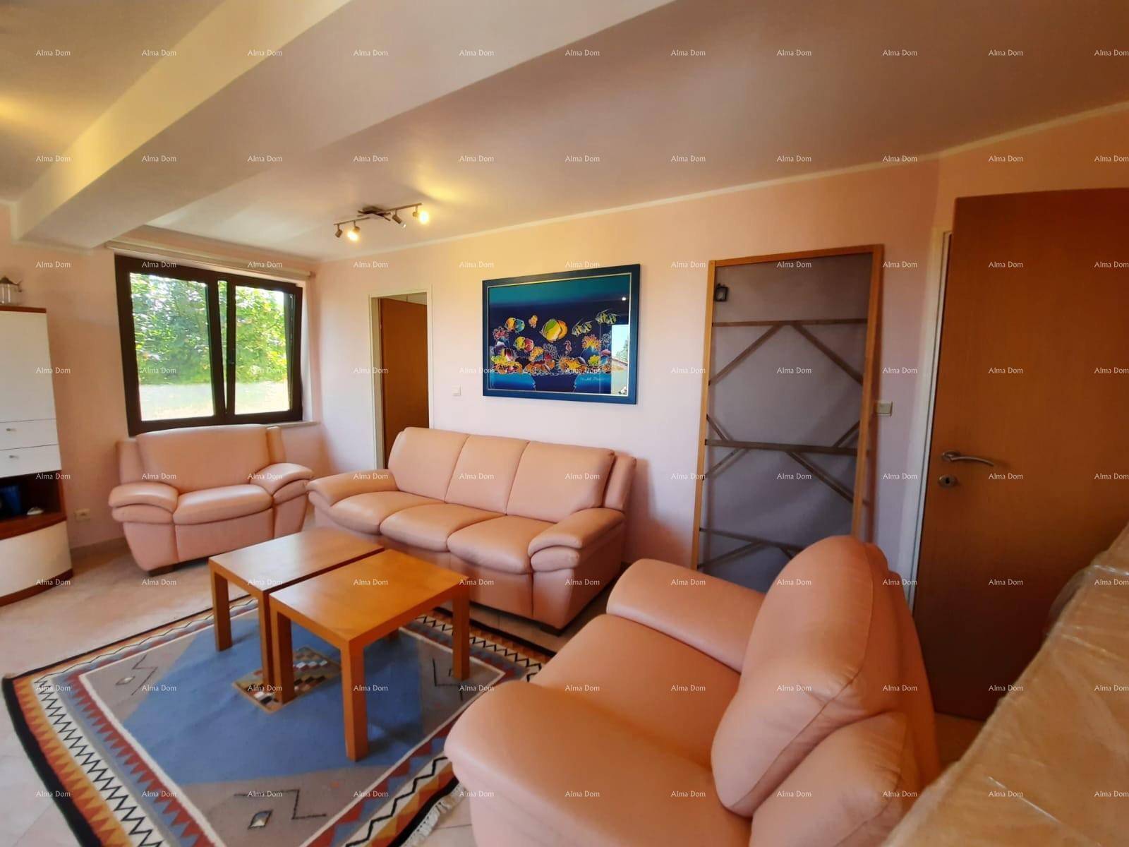 Geräumiges Wohnzimmer mit bequemen Sofas, Fliesenboden und Blick ins Grüne.