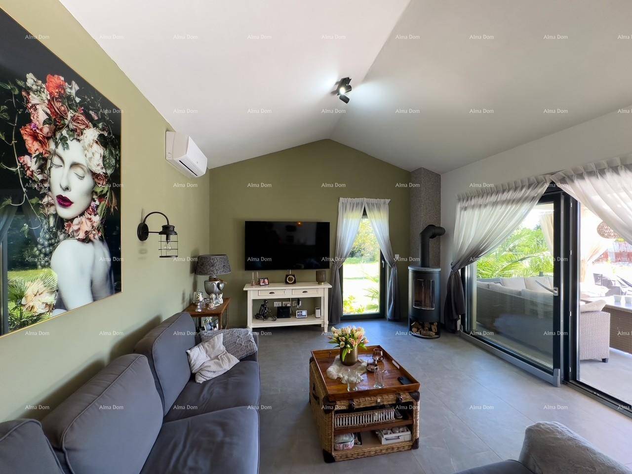 Helles Wohnzimmer mit bequemer Couch, Kaminofen und Blick ins Grüne, schafft eine ruhige Atmosphäre.