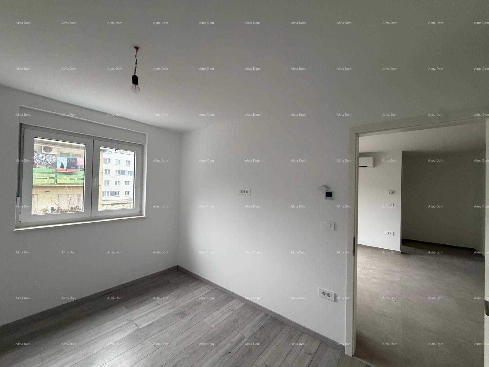 Helles Schlafzimmer im Rohbau mit Laminatboden und Blick aus dem Fenster.