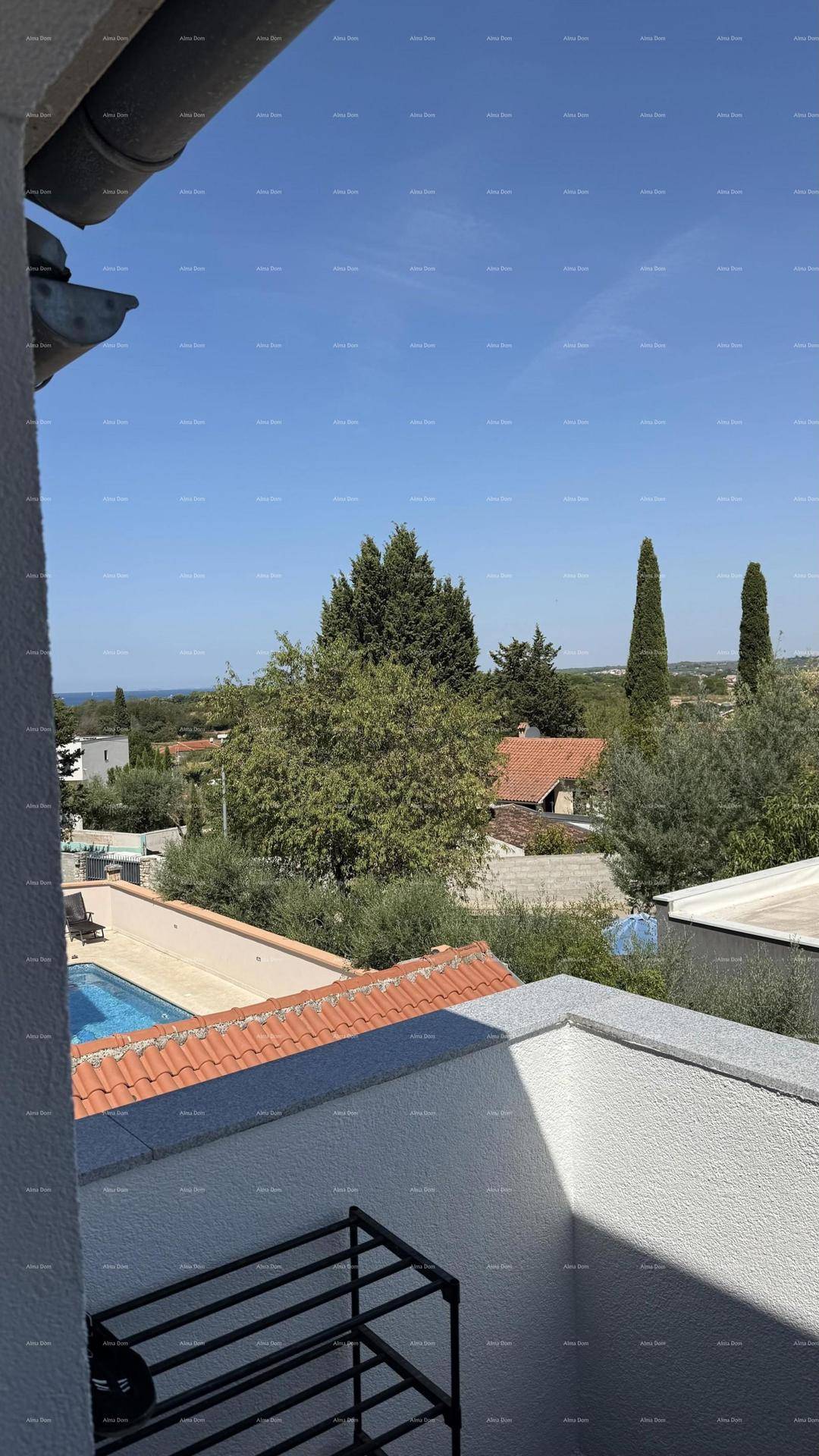 Panoramablick vom Balkon über eine Wohngegend mit Pool und Meer in der Ferne.