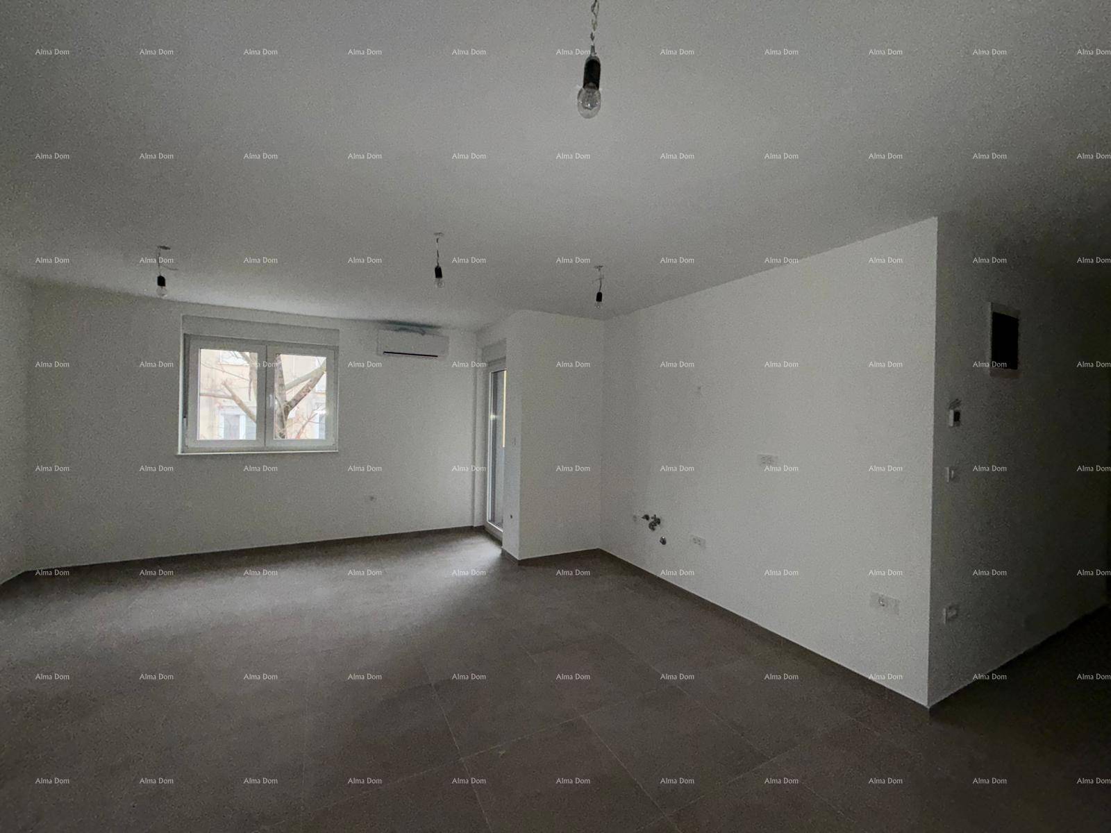 Leeres Wohnzimmer mit hellen Wänden, Fliesenboden und Fenster mit Blick nach draußen.