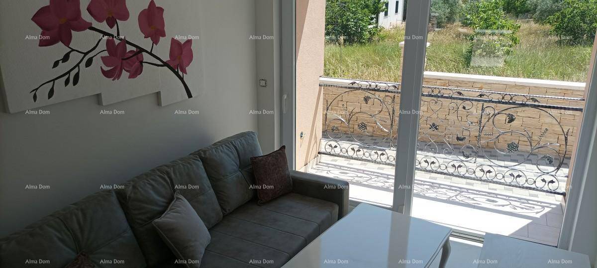 Wohnzimmer mit Sofa, Couchtisch und großem Fenster mit Blick ins Grüne.